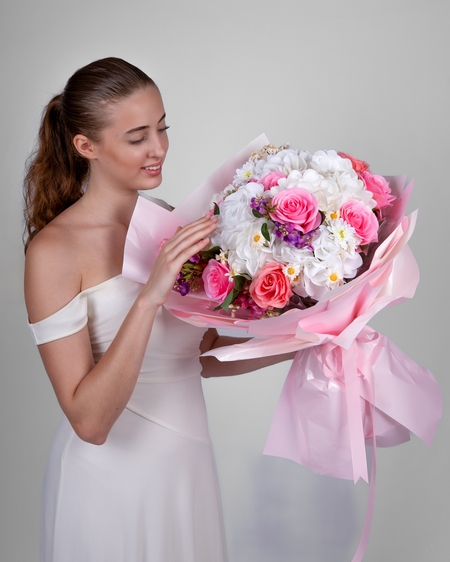 a woman in a white dress holding a bouquet of flowers