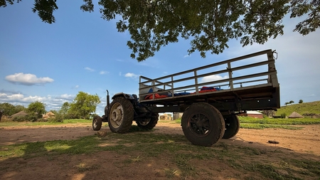 A tractor parked under a tree