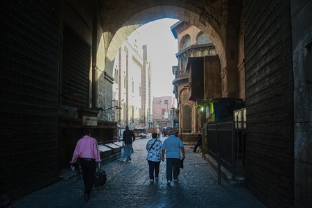 People walking down a narrow street in Old Cairo