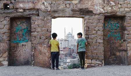 Two kids standing at a doorway