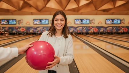 A woman holding a bowling ball in her hand