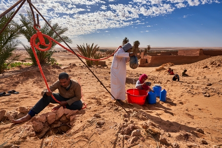 Algerian men drawing water from desert wells