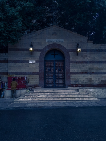A church with stone walls and an arched entrance.