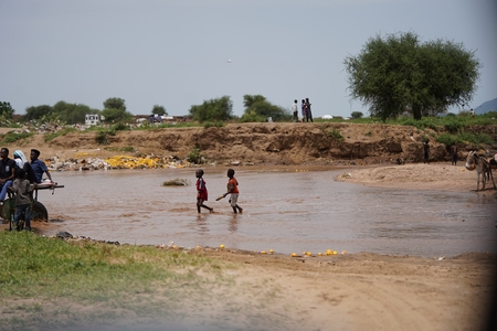 people are wadi in the water near a river