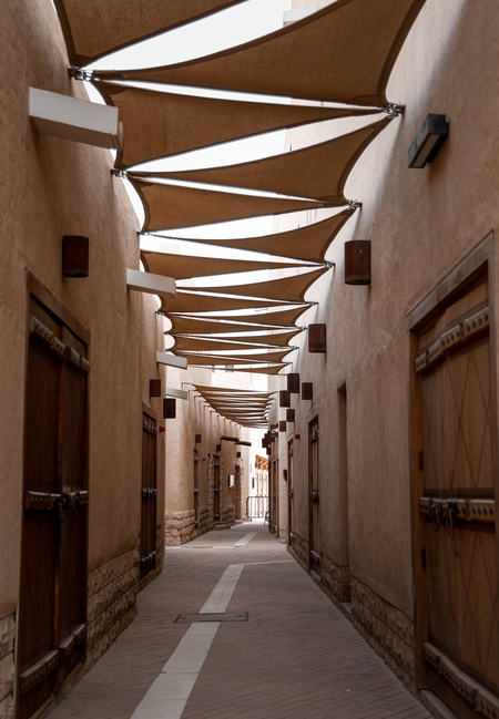 a narrow street with a wooden walkway and a canopy over it
