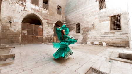 A woman in a green dress dancing in an alley • The Middle Frame • Arab ...