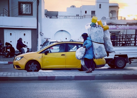 a man in a yellow car with a large bag on his back